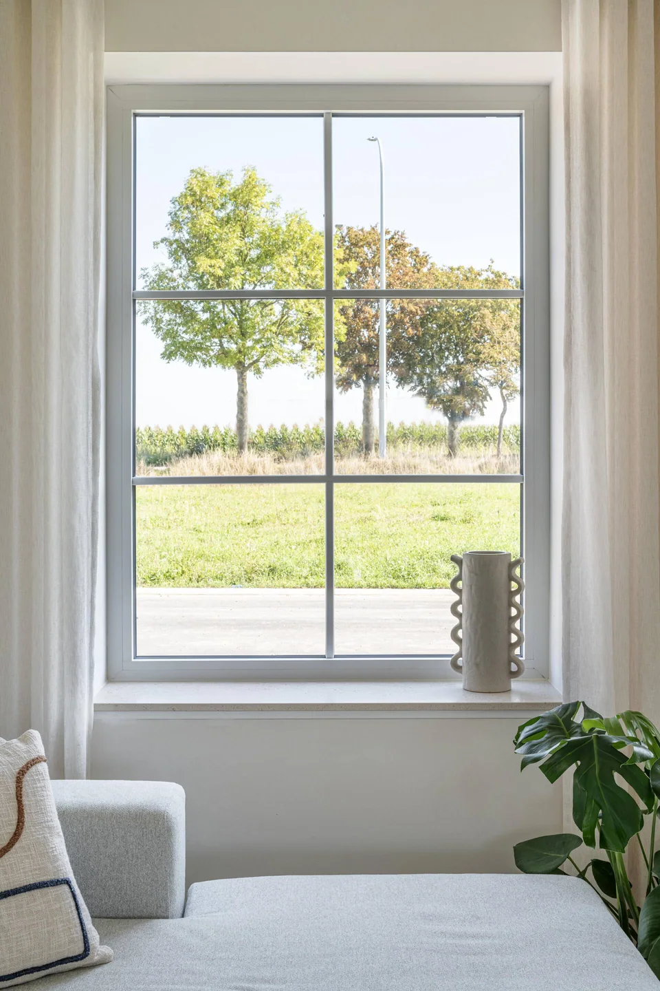 Ventana blanca con vista hacia un jardín